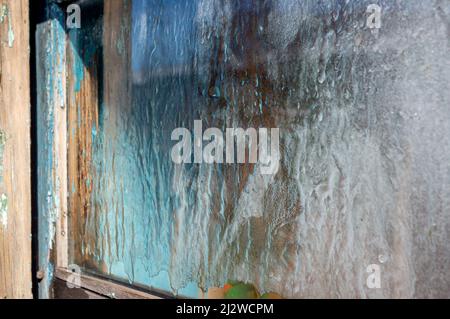 Holzfenster mit Eismustern aus gefrorenem Wasser Stockfoto