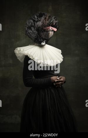 Edle Dame. Weibliche mittelalterliche königliche Person in Vintage-Kleidung mit Hundekopf isoliert auf dunklem Retro-Hintergrund geführt. Konzept des Vergleichs von Epochen Stockfoto