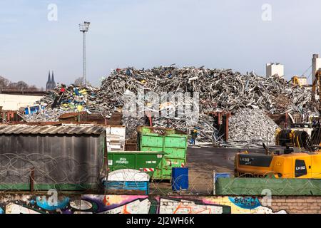 Schrottplatz mit altem Metall im Stadtteil Deutz, im Hintergrund der Dom, Wand mit Graffiti, Köln, Deutschland. Schrottplatz mit Altmetall im Stockfoto