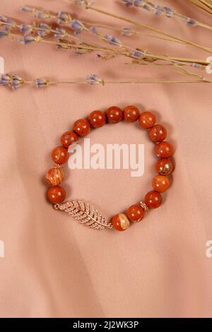 Jaspis-beiges Armband. Armband aus Natursteinen auf der Hand. Stockfoto