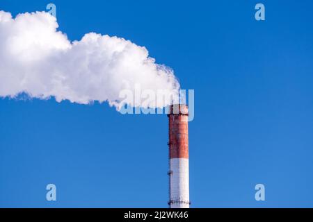 Rauchstapel mit Rauchentwicklung. Anlagenrohre verschmutzen die Atmosphäre. Verschmutzung durch Industriebetriebe. Platz zum Kopieren von Text Stockfoto