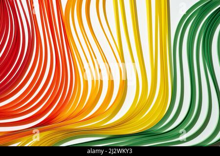 Regenbogenfarbener Papierstreifen zum Quilling. Mehrfarbige Wellen auf weißem Hintergrund Stockfoto