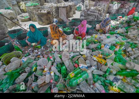 Noakhali, Chittagong, Bangladesch. 4. April 2022, Noakhali, Chittagong, Bangladesch: Arbeiter sortieren gebrauchte Plastikflaschen in einer Recyclingfabrik in Noakhali, Bangladesch. Plastikflaschen, die zur Verpackung von Wasser verwendet werden, brauchen mehr als 1.000 Jahre, um biologisch abbaulich zu werden und, wenn sie verbrannt werden, giftige Dämpfe zu erzeugen. Schwimmende Kunststoffabfälle, die Tausende von Jahren im Wasser überleben können, dienen als Mini-Transportmittel für invasive Arten und stören Lebensräume. Tief in Deponien vergrabener Kunststoff kann schädliche Chemikalien austreten, die sich in das Grundwasser ausbreiten. Kredit: ZUMA Press, Inc./Alamy Live Nachrichten Stockfoto