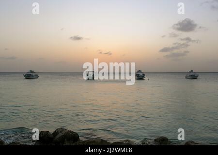 BONAIRE - 6. OKTOBER 2013: Resort Tauchboote vor Anker bei Sonnenuntergang Stockfoto
