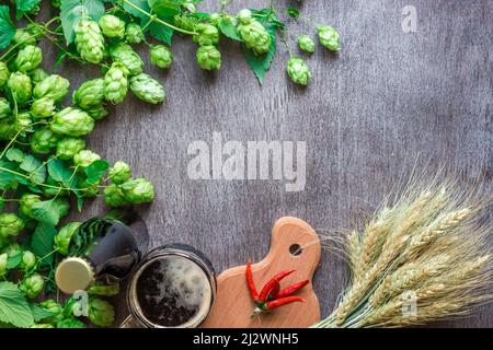 Flasche und Glas Bier mit Weizen und Hopfen als Brauzutaten in Draufsicht und Kopierraum Stockfoto