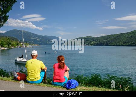 Mann und Frau beim Wandern, sitzen am Millstätter See, Millstätter See, Nockberge Trail, Kärnten, Österreich Stockfoto