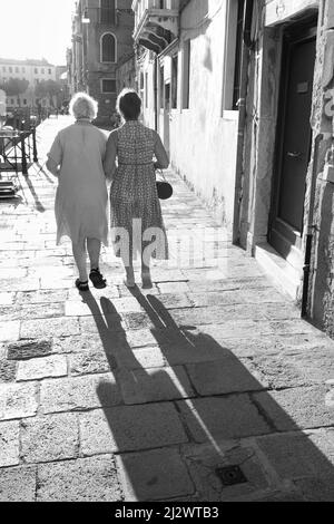 Ältere Frauen, die Arm in Arm gehen, Rückansicht in Venedig, Venedig, Venetien, Italien, Europa Stockfoto