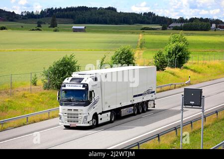 Weißer Volvo FH LKW mit gekühltem Sattelauflieger liefert an einem Sommertag Güter auf der Autobahn E18, erhöhte Sicht. Salo, Finnland. 10. Juli 2020. Stockfoto