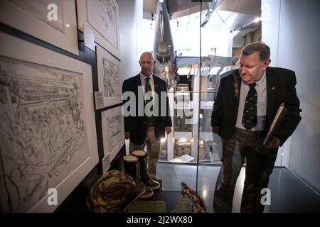 NEW FALKLANDS DISPLAYS ERÖFFNET IM IWM LONDON New Falklands Displays im IWM London, darunter Bilder des professionellen Fotografen Paul Haley und Kunstwerke von Linda Kitson. (Im Bild) Falklands-Veteran Mike Carr, der mit 3 para mit Paul Carr zusammen mit Falklands-Veteran Paul Benton, der an Bord der HMS Invincible diente, diente, stand neben einem Schaukasten, in dem Lara Kitsens Skizzierzeug und Armeekleidung zeigte, die sie während des Falklands-Konflikts verwendete. Kredit: Jeff Gilbert/Alamy Live Nachrichten Stockfoto