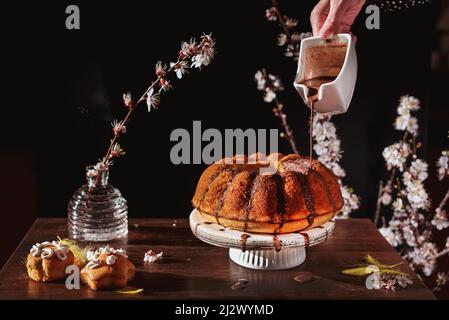 Hausgemachter Kuchen mit Schokoladensauce auf schwarzem Hintergrund, Nahaufnahme, Stillleben-Fotografie Stockfoto