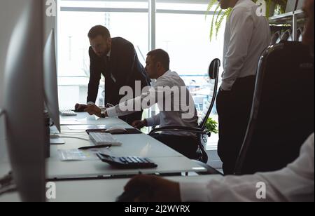 Der Geschäftsführer und die Mitarbeiter des Unternehmens interagieren und sprechen im Büro. Treffen des Leiters mit den Mitarbeitern, um Aufgaben zu besprechen Stockfoto