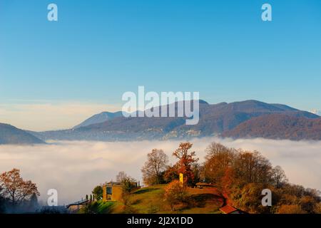 Bergblick über den Luganer See mit Wolkenlandschaft und Sonnenlicht und klarem Himmel in Lugano, Tessin in der Schweiz. Stockfoto