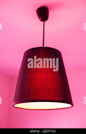 Lampe an der Decke im Zimmer in rosa Licht Stockfoto