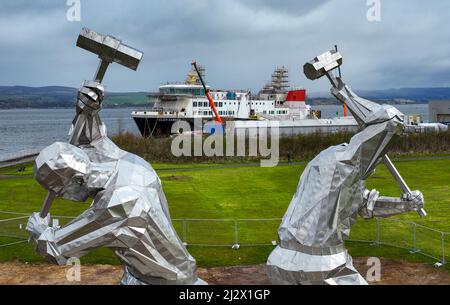 Port Glasgow, Schottland, Vereinigtes Königreich. 4.. April 2022. Die Fähre MV Glen Sannox wird von der neuen Skulptur Shipbuilders of Port Glasgow von John McKenna eingerahmt. Die umstrittene Fähre wird derzeit auf der Ferguson Marine Werft in Port Glasgow gebaut. Der Vertrag über den Bau von zwei Fähren wird voraussichtlich Gegenstand einer Untersuchung des parlamentarischen Ausschusses im schottischen Parlament sein. Iain Masterton/Alamy Live News Stockfoto