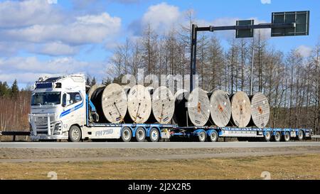 Kundenspezifischer weißer Volvo FH16 750 LKW von T.Lahma Ky transportiert Kabelrollen für Bodeninstallationen auf Tieflader. Forssa, Finnland. 1. April 2021. Stockfoto