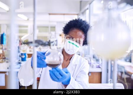 Das Problem durcharbeiten, um eine Lösung zu finden. Aufnahme einer Wissenschaftlerin, die in einem Labor arbeitet. Stockfoto