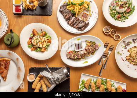 Auswahl an verschiedenen internationalen Gerichten, mit venezolanischer tequeños, japanischem rotem Thunfisch-Tataki, spanischem gegrilltem Entrecote, italienischem Burrata-Salat und Spani Stockfoto