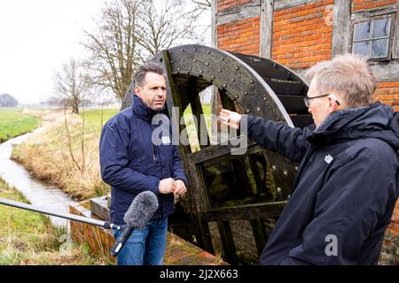 Warpe, Deutschland. 04. April 2022. Olaf Lies (M, SPD), Umweltminister von Niedersachsen, spricht mit Klaus Gänsslen (r), Leiter des Unteren Naturschutzamtes des Landkreises Nienburg/Weser, der vor einer Wassermühle steht, während der Präsentation der zentralen Aspekte des Landschaftsprogramms im Landkreis Nienburg/Weser. Quelle: Moritz Frankenberg/dpa/Alamy Live News Stockfoto