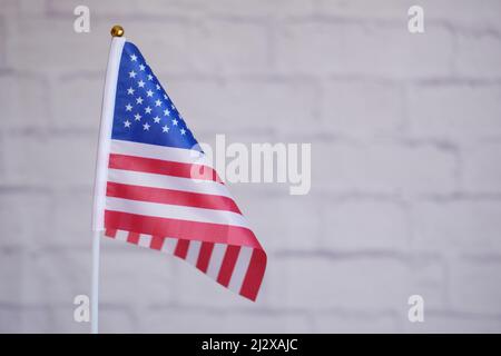 amerikanische Flagge gegen weiße Wand Stockfoto