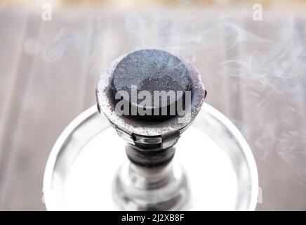 Nahaufnahme der Shisha Wasserpfeife, die Holzkohle verbrennt, Funken fliegen, Rauch kommt. Stockfoto