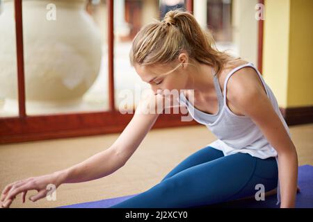 Die perfekte Übung, um Stress abzubauen. Aufnahme einer jungen Frau, die zu Hause Yoga macht. Stockfoto