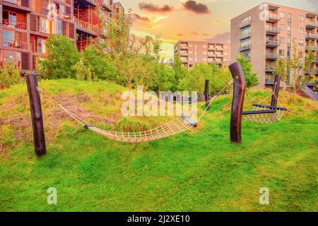 Hängematten auf Holzpfosten auf grünem Gras stehen auf dem Hof in der Nähe der Tietgen Studentenhalle Tietgenkollegiet in Kopenhagen, Dänemark Stockfoto