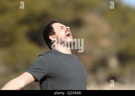 Aufgeregt schreit der Mensch in der Natur in die Luft Stockfoto