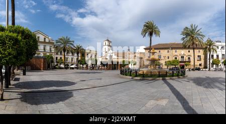 Merida, Spanien -- 28. März 2022: Panoramablick auf den Plaza de Espana im Stadtzentrum von Merida mit seinem Brunnen und Palmen Stockfoto