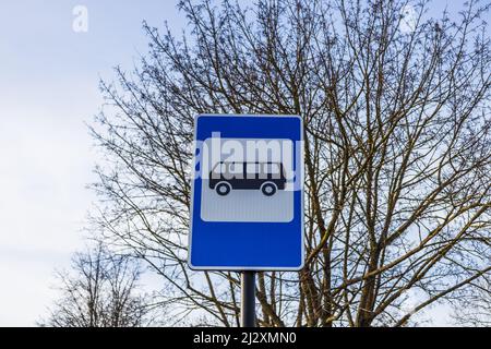 Blau-weißes Bushalteschild in Europa auf dem Himmelshintergrund Stockfoto