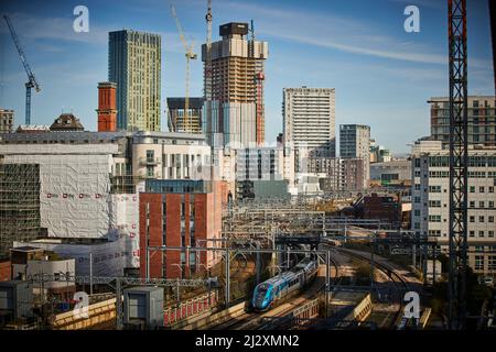 Die Grenze zu Manchester Salford mit einem Neubau auf der Skyline von Salford und einem TPE-Zug nähert sich Manchester Victoria Stockfoto