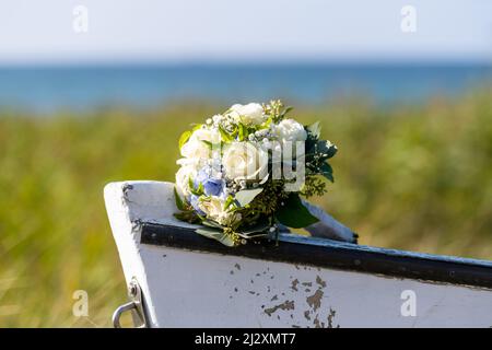 Blumenstrauß mit Rosen und Hortensien auf der Spitze eines Holzbootes Stockfoto