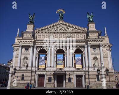 Lviv, Ukraine, 25. März 2022. Solomiya Krushelnytska Lviv Staatliches Akademisches Theater für Oper und Ballett an einem sonnigen Tag. Plakate an der Fassade des Stockfoto