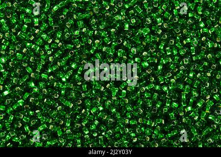 Viele glänzende grüne Glasperlen auf Makro in Texturform. Stockfoto