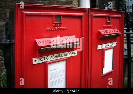 Altes englisches Postfach. Ein Paar altmodischer englischer Briefkästen mit Metallplatten an Ort und Stelle, die den Postweg auf normale Briefe beschränken. Stockfoto