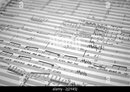 Manuskript „Musik“. Vollständiger, selektiver Fokus auf eine offene Orchesterpartitur. Stockfoto