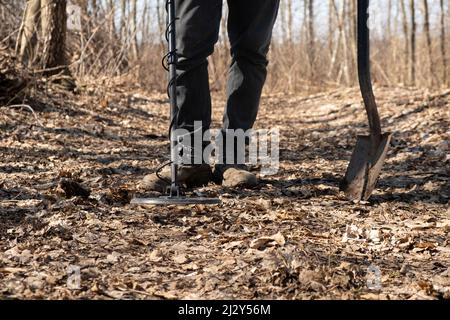 Mit einem Metalldetektor sucht der Mensch Münzen entlang alter Straßen. Stockfoto