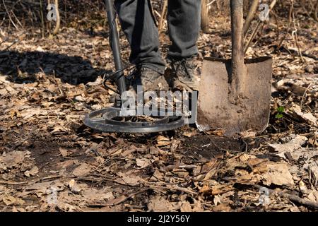 Mit einem Metalldetektor sucht der Mensch Münzen entlang alter Straßen. Stockfoto