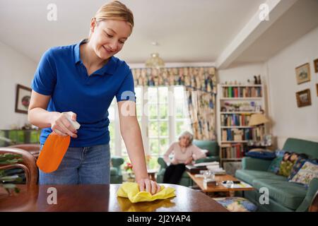 Weibliches Zuhause Hilfe Reinigung Haus Und Im Gespräch Mit Älteren Frau Stockfoto