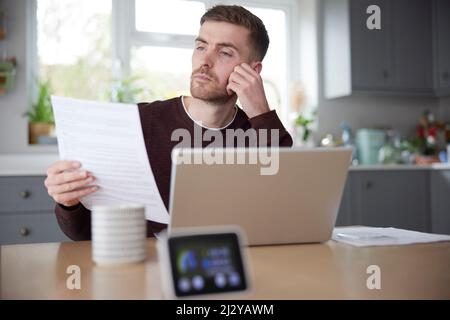 Smart Energy Meter In Der Küche Messung Von Strom Und Gas Mit Mann Blick Auf Rechnungen Stockfoto