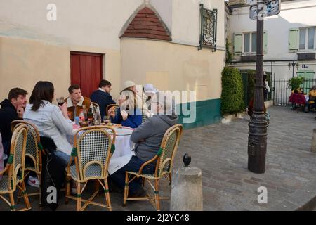 Paris, Frankreich - 5. März 2022: Menschen essen auf der Terrasse auf dem plaza im malerischen Viertel Montmartre in Paris, Frankreich. Stockfoto