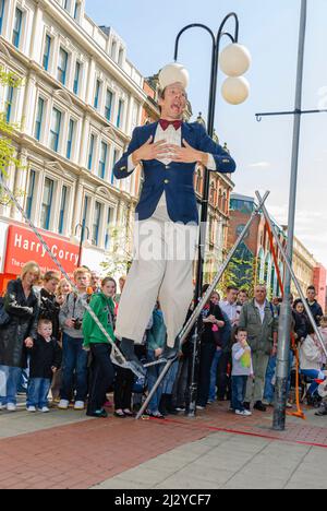 Belfast, Nordirland. 3. Mai 2008. Ein Straßenkünstler geht eine Gratwanderung, während er vor einem Publikum vor dem Castle Court Einkaufszentrum auftritt. Stockfoto