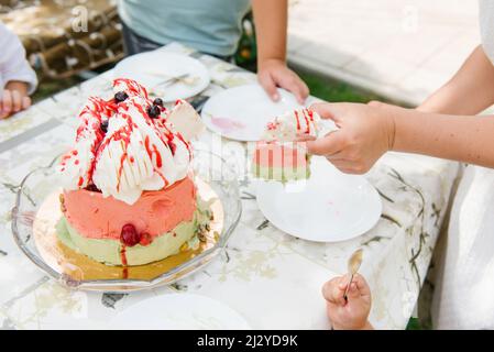 Der Eiskuchen wird in Stücke geschnitten und auf Teller gelegt Stockfoto