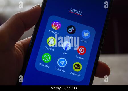 Symbole für Social-Media-Apps auf dem Bildschirm, mit der Hand des Smartphones. Afyonkarahisar, Türkei - 4. April 2022. Stockfoto