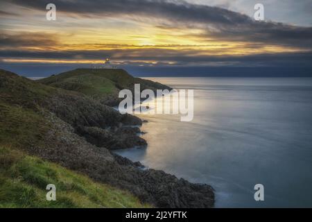 Blick entlang der Küste in Richtung Sonnenuntergang am Strumble Head Lighthouse in Trefasser, Wales, Großbritannien. Stockfoto