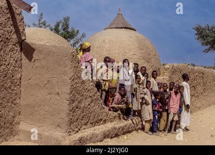 Niger, Westafrika. Nigerische Dorfbewohner, Kornkammer hinter ihnen. Stockfoto