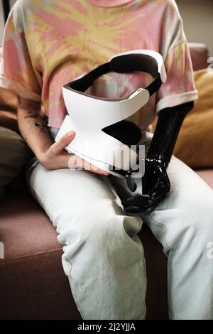 Nahaufnahme eines Mädchens mit einem prothetischen Arm mit Virtual-Reality-Simulator für die Rehabilitation Stockfoto