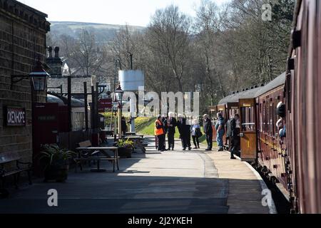 Passagiere und Bahnhofsbeamte in Oxenhope, wenn das Boarding für den morgendlichen Abflug nach Keighley auf der historischen Eisenbahnlinie beginnt Stockfoto