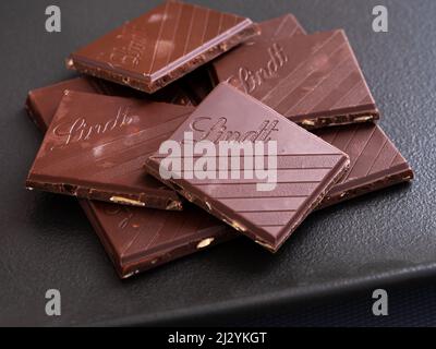 Tambow, Russische Föderation - 29. März 2022 Stücke Lindt Schokolade auf einem schwarzen Teller. Stockfoto