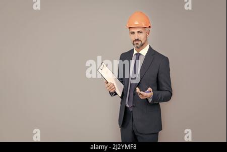 ceo mit Baudokumenten. Reifer Chef mit Clipboard. Zuversichtlich Geschäftsmann in Helm Stockfoto