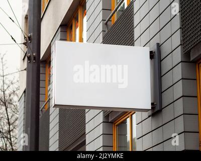 Leeres Display an der Fassade eines Unternehmens im Gebäude. Vorlage zum Testen eines Logos oder eines Schildes neben einer Wand. Unbeschriftete Werbung für eine Marke. Stockfoto